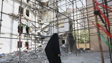 ARCHIVO - Una mujer pasa junto a un edificio dañado por un letal ataque israelí el 13 de junio, en un complejo residencial en Teherán, Irán, el 19 de julio de 2025. (AP Foto, archivo)