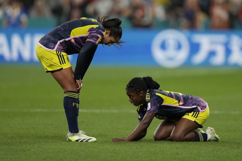 Linda Caicedo, derecha, yace en el césped con una aparente lesión, mientras su compañera de la selección de Colombia Manuela Vanegas la revisa durante el partido de la Copa del Mundo del Grupo H contra Alemania, en el estadio Sydney Football Stadium, en Sidney, Australia, el domingo 30 de julio de 2023. (AP Foto/Rick Rycroft)