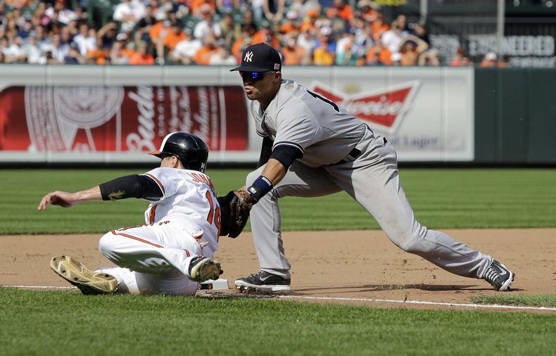 El yanqui Mart&iacute;n Prado (der) pone out a Kelly Johnson, de los Orioles, en la tercera base el 12 de septiembre del 2014 en Baltimore. El venezolano sufre de apendicitis y estar&aacute; inactivo al menos dos meses. (AP Photo/Patrick Semansky)
