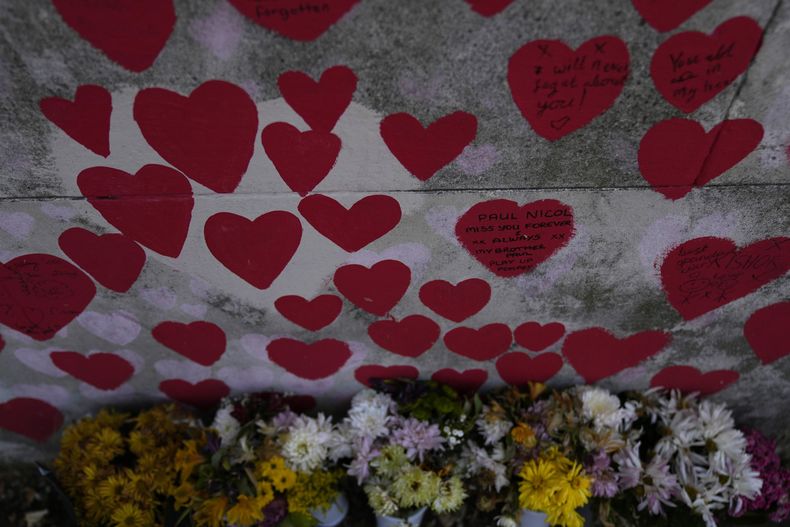Flores colocadas en el Muro Conmemorativo Nacional del COVID dedicado a los muertos en la pandemia, Londres, martes 13 de junio de 2023. Una vasta investigación pública sobre la respuesta británica a la pandemia, presentada el martes, comienza con un capítulo que indaga en si se podría haber evitado tanto sufrimiento y muertes con una mejor planificación. (AP Foto/Alastair Grant)