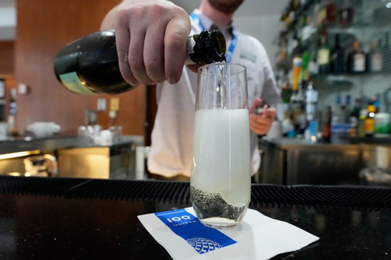 Un camarero sirve un vaso de vino espumoso en la sala de United Club, el lunes 29 de junio de 2026, en Minneapolis, Minnesota. (AP Foto/Chris Carlson)