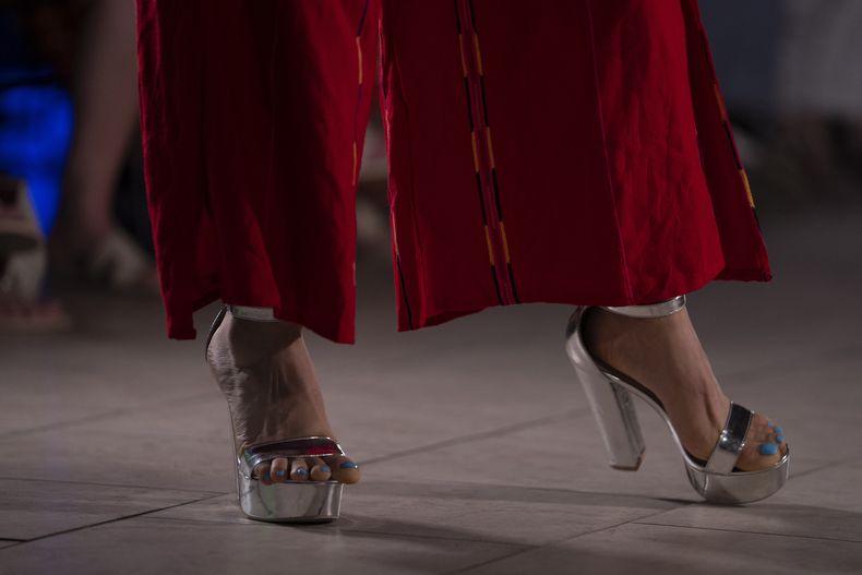 Esta fotografía muestra los zapatos de una modelo que luce prendas durante un desfile de modas con textiles guatemaltecos, el viernes 12 de mayo de 2023, en Brownsville, Texas. Elena de León, una diseñadora nacida en Guatemala, combinó técnicas indígenas de tejido, diseño moderno de ropa y colorida historia de su país natal en esa exhibición, la cual ofreció una muestra no sólo de su visión artística, sino un trabajo de madres guatemaltecas, incluidas algunas que viven en Estados Unidos y otras que se quedaron en su país para apoyar a sus familias. (AP Foto/Julio Cortez)