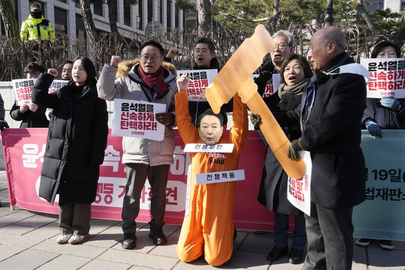 Un manifestante con una máscara del presidente surcoreano Yoon Suk Yeol, que ha sido apartado del cargo, asiste con otros manifestantes a una marcha para pedir la renuncia de Yoon ante la Corte Constitucional en Seúl, Corea del Sur, el miércoles 19 de febrero de 2025. El cartel dice juzguen rápido a Yoon Suk Yeol. (AP Foto/Ahn Young-joon)