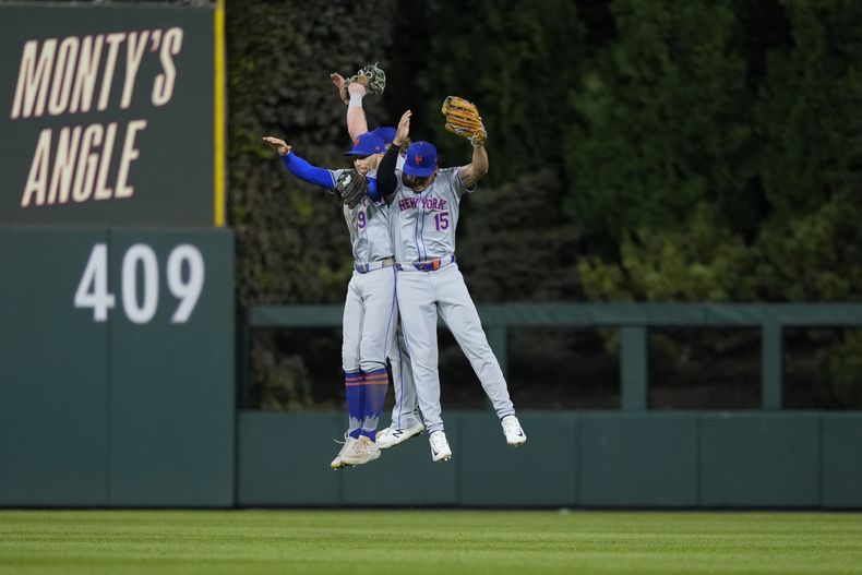 Brandon Nimmo (9) y Tyrone Taylor (15), de los Mets de Nueva York, celebran después de ganar el Juego 1 de una Serie Divisional de la Liga Nacional contra los Filis de Filadelfia, el sábado 5 de octubre de 2024, en Filadelfia. (AP Foto/Matt Slocum)