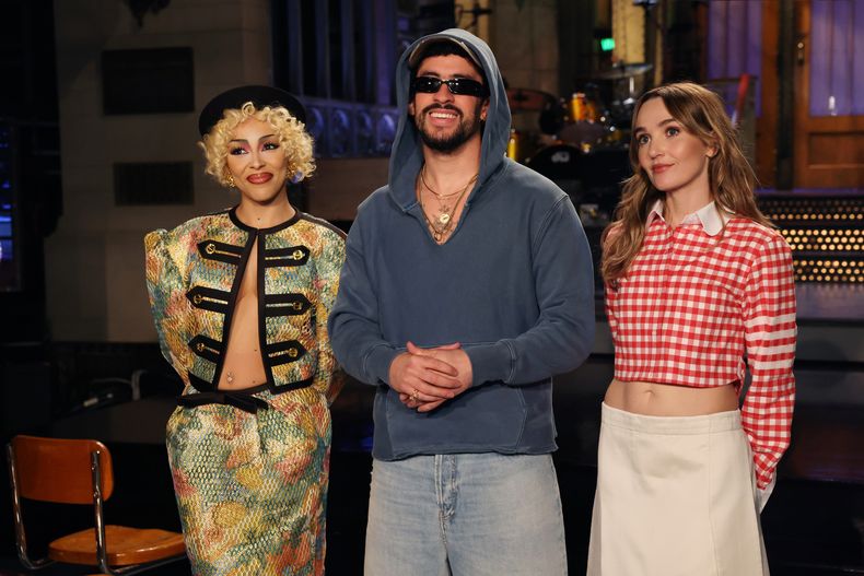 Esta imagen publicada por NBC muestra al presentador Bad Bunny, en el centro, con la invitada musical Doja Cat, a la izquierda, y la miembro del elenco Chloe Fineman durante la grabación de anuncios promocionales para el próximo Saturday Night Live el jueves 2 de octubre de 2025. (Rosalind OConnor/NBC via AP)