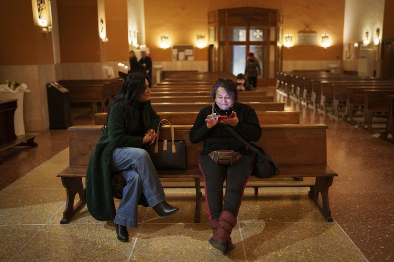 Carla Segovia, a la izquierda, y Minerva, que son trans, se sientan en la iglesia Bendita Virgen Inmaculada en Torvaianica, Italia, el jueves 27 de febrero de 2025. (AP Foto/Bernat Armangue)