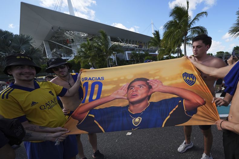Hinchas del Boca Juniors posan para una foto con una imagen del presidente del club, Juan Román Riquelme, afuera del estadio antes del partido de fútbol del grupo C del Mundial de Clubes entre el Boca Juniors y el Benfica en Miami Gardens, Florida, el lunes 16 de junio de 2025. (AP Photo/Rebecca Blackwell)