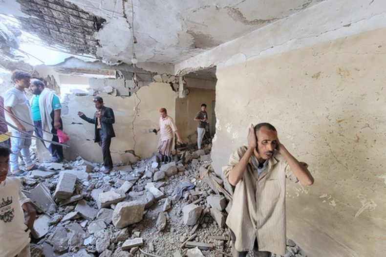 Varios residentes caminan entre los escombros de sus casas en el distrito Seina en Taiz, Yemen, tras un ataque con misil, el martes 20 de octubre de 2026. (AP Foto/Marzouq Al Jabri)