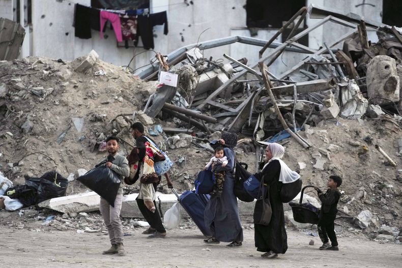 Palestinos evacúan después de que el ejército de Israel emitió una advertencia de evacuación para varias escuelas y un hospital en el vecindario de Rimal, el miércoles 14 de mayo de 2025, en Ciudad de Gaza. (AP Foto/Jehad Alshrafi)