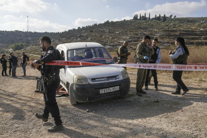 Soldados israelíes examinan el auto usado por un palestino que realizó disparos cerca de un asentamiento de colonos israelíes en Cisjordania, el jueves 6 de julio de 2023. }(AP Foto/Mahmoud Illean)
