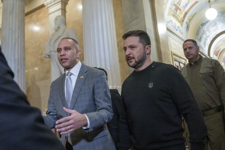 El líder del bloque demócrata en la cámara baja, Hakeem Jeffries, izquierda, camina junto al presidente ucraniano Volodymyr Zelenskyy a una reunión con otros legisladores en el Capitolio, Washington, martes 12 de diciembre de 2023. (AP Foto/Alex Brandon)