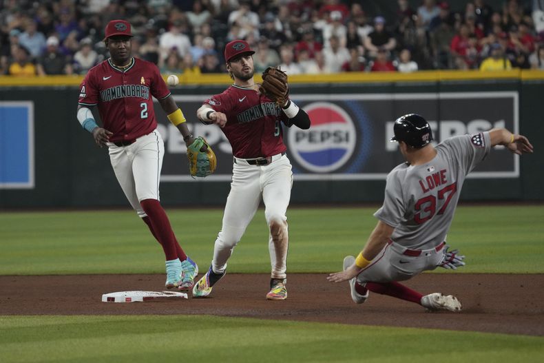 El segunda base de los Diamondbacks de Arizona, Blaze Alexander (9), convierte la doble matanza mientras evita a Nathaniel Lowe (37), de los Medias Rojas de Boston, en una pelota bateada por Rob Refsnyder en la cuarta entrada de un juego de béisbol, el domingo 7 de septiembre de 2025, en Phoenix. (AP Photo/Rick Scuteri)