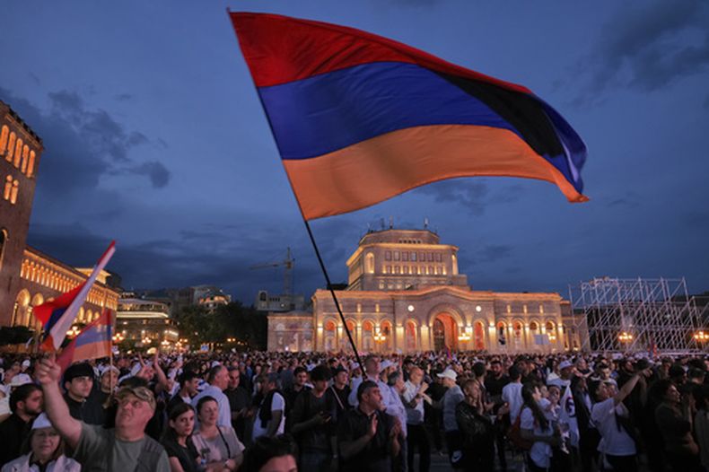 Partidarios del magnate ruso-armenio Samvel Karapetyan ondean una bandera nacional armenia durante una protesta contra el primer ministro en funciones, Nikol Pashinyan, en la Plaza de la República de Ereván, Armenia, el miércoles 3 de junio de 2026. Karapetyan, líder del partido Armenia Fuerte, enfrenta cargos penales que él rechaza por considerarlos políticamente motivados y realiza campaña desde su arresto domiciliario. (Foto AP/Anthony Pizzoferrato)