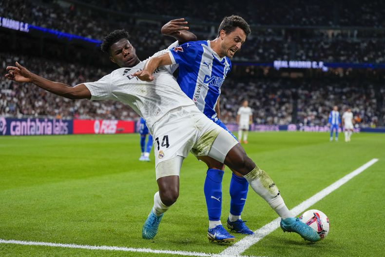 Aurelien Tchouameni, al frente, del Real Madrid, se bate en duelo por el balón con Ander Guevara, del Alavés, durante un partido de La Liga española entre el Real Madrid y el Alavés en el estadio Santiago Bernabéu en Madrid, España, el martes 24 de septiembre de 2024. (AP Foto/Manu Fernández)