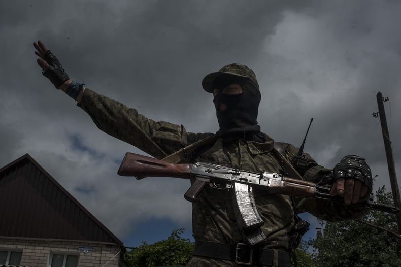 Un combatiente prorruso monta guardia en un ret&eacute;n en Slaviansk, Ucrania, 12 de junio de 2014. La ciudad ha sido el epicentro desde hace dos meses del enfrentamiento entre las fuerzas ucranianas y los rebeldes prorrusos. (AP Foto/Evgeniy Maloletka)