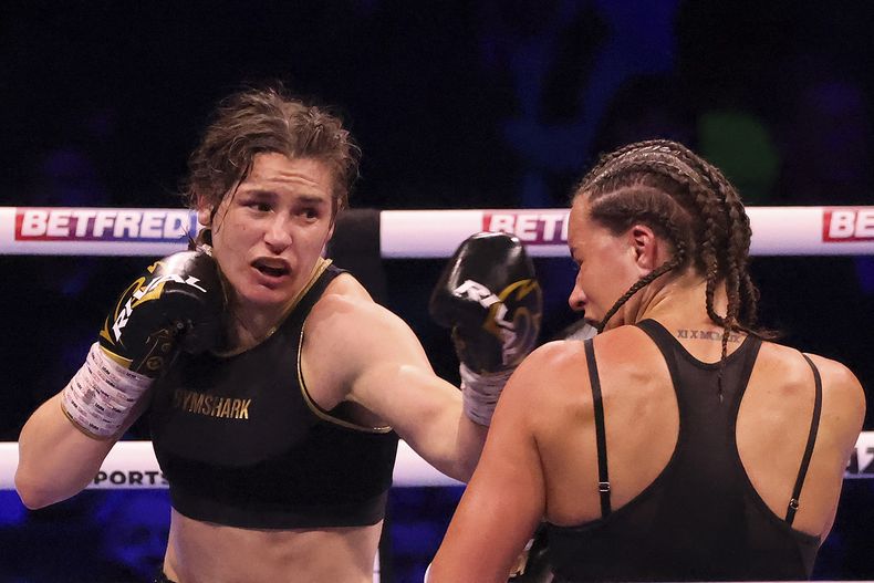 ARCHIVO - La irlandesa Katie Taylor, izquierda, golpea a la británica Chantelle Cameron durante su pelea de título mundial en peso welter ligero, en la 3Arena en Dublín, Irlanda, el sábado 20 de mayo de 2023. La campeona mundial indiscutible de peso ligero Katie Taylor ha cuestionado si el boxeo femenino tiene la “fuerza y profundidad” para pasar a rounds de tres minutos. (AP Foto/Peter Morrison, Archivo)