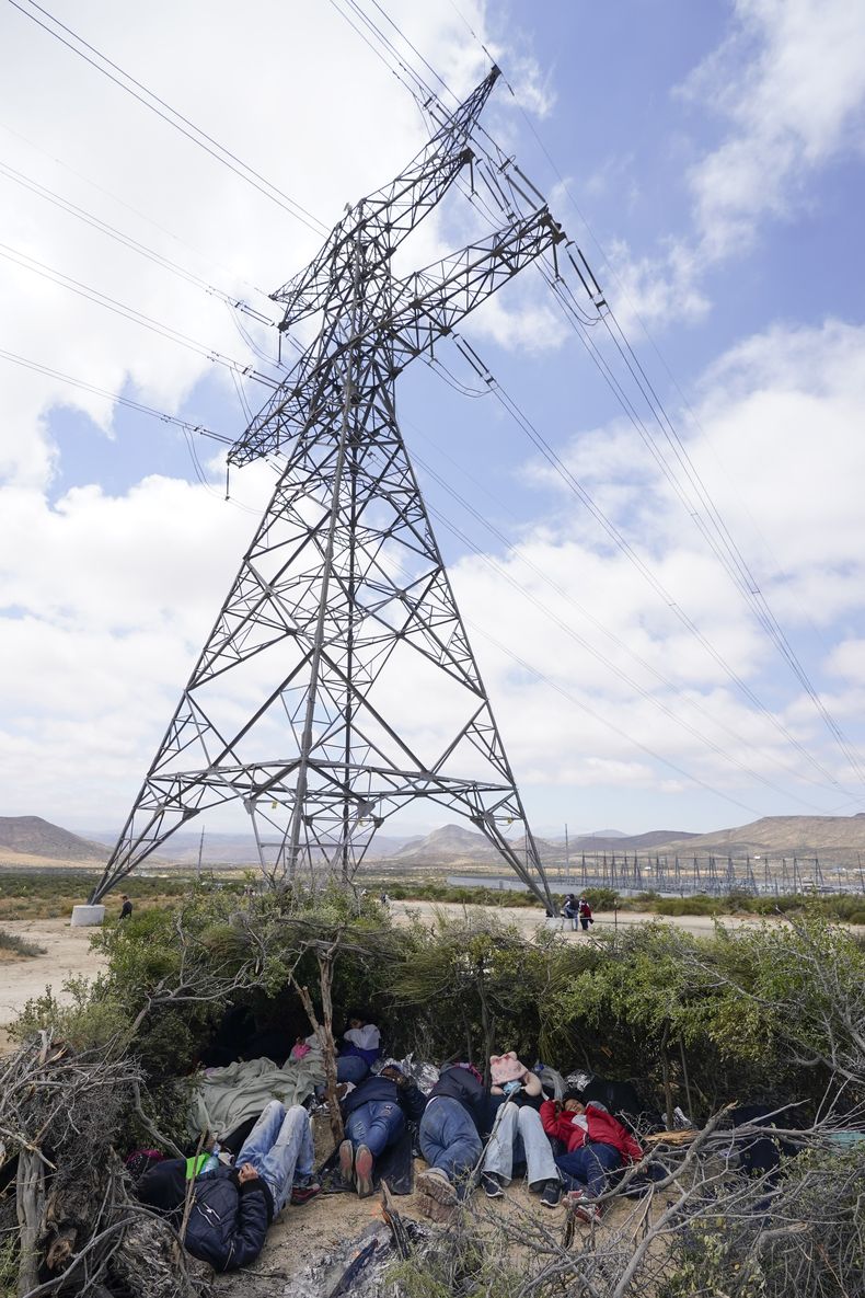 Un grupo de migrantes duerme en un campamento improvisado mientras aguardan a solicitar asilo después de cruzar la frontera, el miércoles 10 de mayo de 2023, cerca de Jacumba, California. El grupo ha estado acampando del otro lado de la frontera durante días, a la espera de pedir asilo en Estados Unidos. A partir del jueves, el gobierno del presidente Joe Biden comenzará a negar asilo a los migrantes que se presenten en la frontera con México sin haber presentado primero una solicitud en línea o haber pedido protección en un país por el que pasaron. (AP Foto/Gregory Bull)