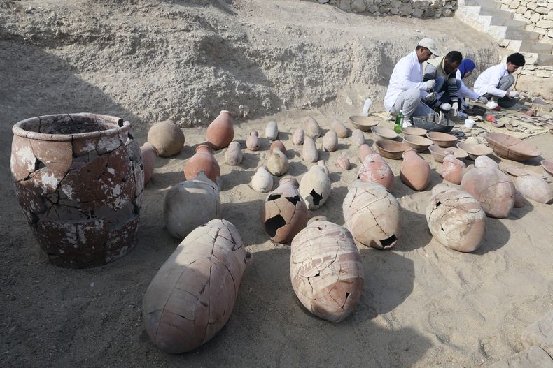 Arqueólogos egipcios revisan artefactos recientemente descubiertos por la misión de la Fundación Zahi Hawass para Antigüedades y Patrimonio, en la calzada del templo funerario de la reina Hatshepsut, en Deir al-Bahri en la orilla occidental del Nilo, en Luxor, Egipto, el miércoles 8 de enero de 2025. (AP Foto/Khaled Elfiqi)
