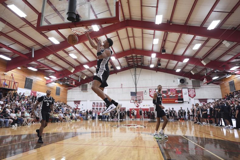 El alero de los Spurs de San Antonio Carter Bryant y sus compañeros realizan jugadas durante una visita al Tom Moore High School en Ingram, Texas el miércoles 10 de septiembre del 2025. (AP Foto/Eric Gay)