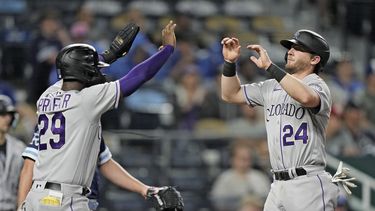 Jurickson Profar (29) y Ryan McMahon (24), de los Rockies de Colorado, celebran después de anotar con doble de Elías Díaz durante la octava entrada del juego de béisbol en contra de los Reales de Kansas City, el viernes 2 de junio de 2023, en Kansas City, Missouri. (AP Foto/Charlie Riedel)