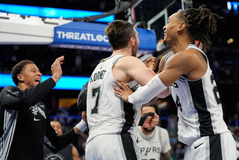 Luke Kornet (7), de los Spurs de San Antonio, celebra con sus compañeros de equipo después de bloquear un tiro de Franz Wagner, del Magic de Orlando, para ganar el partido de baloncesto de la NBA del miércoles 3 de diciembre de 2025, en Orlando, Florida. (AP Foto/John Raoux)