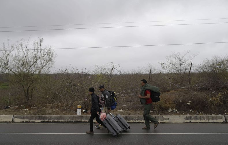 ARCHIVO - Migrantes venezolanos caminan por la autopista panamericana tras cruzar la frontera de Perú antes de la fecha límite para que rijan nuevas regulaciones que exigen pasaporte a los migrantes, en Tumbes, Perú, el 24 de agosto de 2018. Perú extenderá la exigencia de visa y pasaporte a todos los venezolanos que quieran entrar a su territorio desde el próximo 2 de julio, según una nueva norma publicada el jueves 27 de junio de 2024. (AP Foto/Martín Mejía, Archivo)