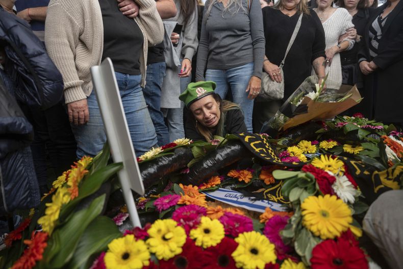 Gali la madre del soldado israelí Sargento Yahav Maayan muerto en combate en la Franja de Gaza, junto a la tumba de su hijo durante su funeral en un cementerio militar en Modiin, Israel, domingo, 12 de enero de 2025. (AP foto/Ohad Zwigenberg)