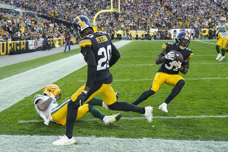 Keanu Neal (31), de los Steelers de Pittsburgh, intercepta un pase que buscaba las manos de Christian Watson (9) de los Packers de Green Bay, durante la segunda mitad del juego de la NFL el domingo 12 de noviembre de 2023, en Pittsburgh. (AP Foto/Matt Freed)