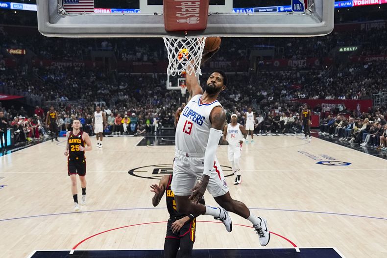 ARCHIVO - El alero de los Clippers de Los Ángeles, Paul George (13), clava durante la primera mitad de un partido de baloncesto de la NBA contra los Hawks de Atlanta en Los Ángeles, el domingo 17 de marzo de 2024. George firmará un contrato de cuatro años y 212 millones de dólares con los 76ers de Filadelfia, dijo a The Associated Press una persona con conocimiento del movimiento el lunes 1 de julio de 2024. (AP Foto/Ashley Landis, ARCHIVO)