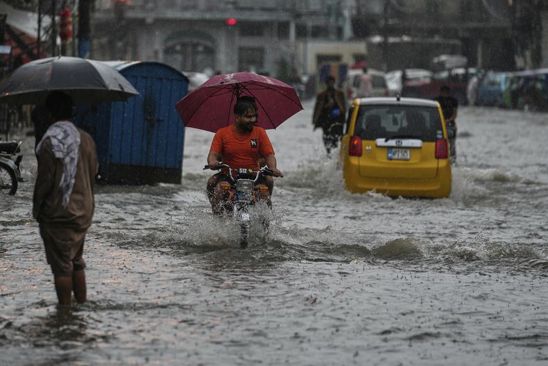 Conductores manejan por una calle inundada durante las lluvias del monzón, en Rawalpindi, Pakistán, el jueves 17 de julio de 2025. (AP Foto/Anjum Naveed)