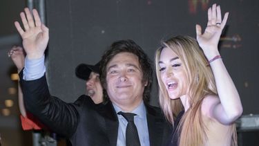 El candidato presidencial de la coalición Libertad Avanza, Javier Milei, y su novia, Fátima Florez, saludan a simpatizantes reunidos fuera de su sede de campaña después de ganar el balotaje, el domingo 19 de noviembre de 2023, en Buenos Aires. (AP Foto/Rodrigo Abd)