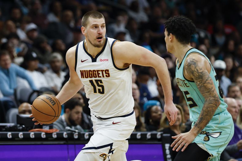 El serbio Nikola Jokic, pívot de los Nuggets de Denver, conduce el balón frente a KJ Simpson, de los Hornets de Charlotte, en el encuentro del sábado 1 de febrero de 2025 (AP Foto/Nell Redmond)