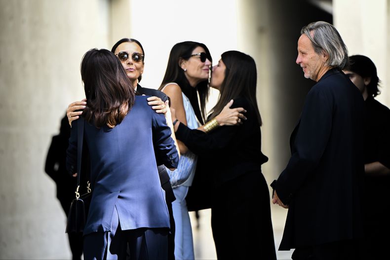 Asistentes al funeral del diseñador de moda Giorgio Armani, quien es velado en el Armani/Teatro en Milán, en el norte de Italia, intercambian condolencias, el sábado 6 de septiembre de 2025. (Foto AP/Nicola Marfisi)