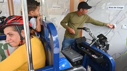 Lorenzo Ravelo, a la derecha, enchufa su triciclo eléctrico en una estación solar en Santa Clara, Cuba, el sábado 2 de mayo de 2026. (AP Foto/Jorge Luis Baños)