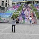 Fans posan junto a un retrato de Taylor Swift pintado en una escalera en el estadio de Wembley en Londres, el miércoles 14 de agosto de 2024, antes de una serie de conciertos de Taylor Swift que comienzan el jueves. (Foto AP/Alastair Grant)