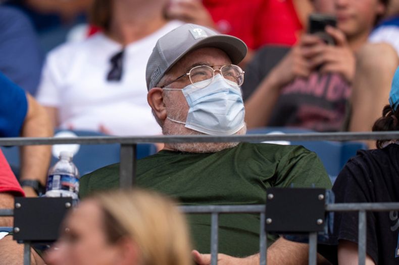 Un aficionado lleva mascarilla durante una alerta por la mala calidad del aire debido al humo de los incendios forestales, antes del partido de béisbol entre los Mets de Nueva York y los Filis de Filadelfia, el jueves 16 de julio de 2026, en Filadelfia. (Foto AP/Chris Szagola)
