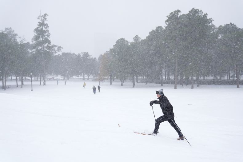 Una persona utiliza esquís de travesía para cruzar una colina cubierta de nieve en el parque Herman, en Houston, el martes 21 de enero de 2025. (AP Foto/Ashley Landis)