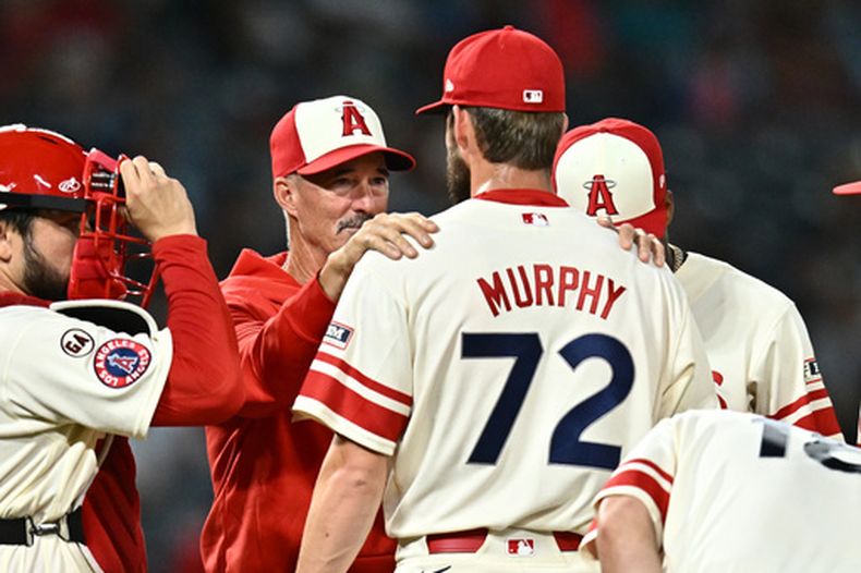 El lanzador de los Angelinos de Los Ángeles, Luke Murphy (72), habla con el coach de pitcheo Mike Maddux (segundo desde la izquierda), durante la octava entrada de un partido de béisbol contra los Cerveceros de Milwaukee, el viernes 31 de julio de 2026, en Anaheim, California. (Foto AP/William Liang)