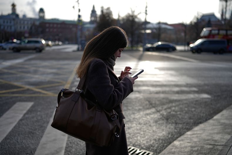 Una mujer mira su celular en el centro de Moscú, Rusia, el 20 de noviembre de 2025. (AP Foto/Alexander Zemlianichenko)