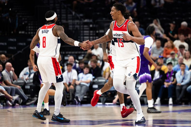 El alero de los Wizards de Washington, Juju Reese (15), y el base de los Wizards de Washington, Jaden Hardy (8), chocan los cinco durante la segunda mitad de un juego de baloncesto de la NBA contra el Jazz de Utah, el miércoles 25 de marzo de 2026, en Salt Lake City. (Foto AP/Anna Fuder)