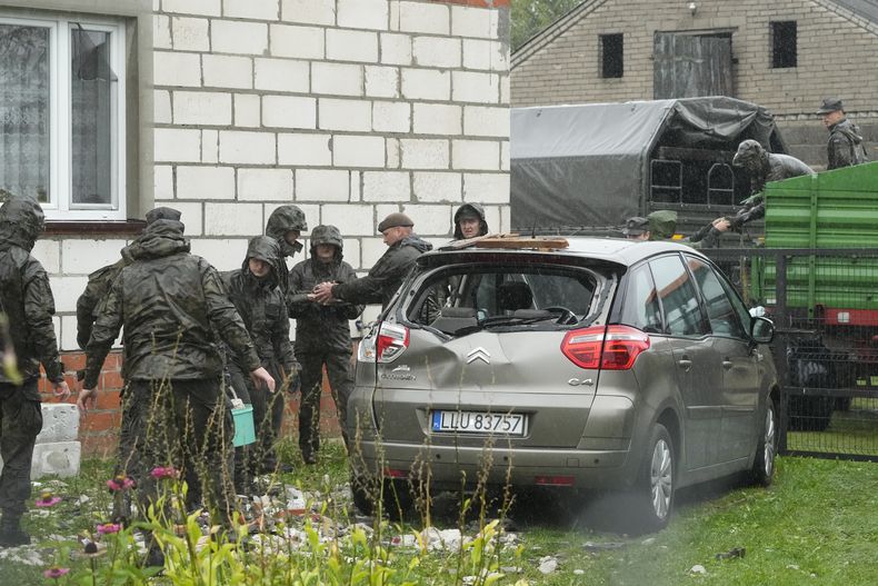 Agentes de defensa territorial retiran los restos del techo destruido de una vivienda, después de que drones rusos violara el espacio aéreo de Polonia en un ataque contra Ucrania, en Wyryki, cerca de Lublin, Polonia, el jueves 11 de septiembre de 2025. (AP Foto/Czarek Sokolowski)