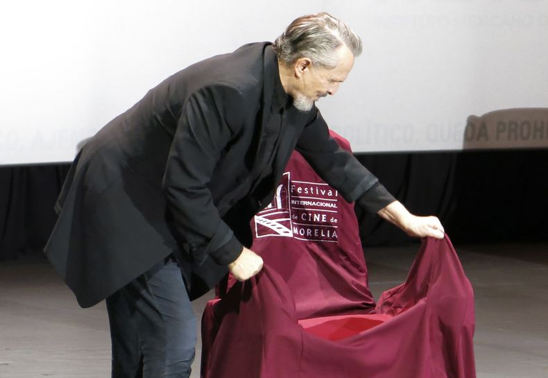 El cantante y actor español Miguel Bosé devela una butaca con su nombre durante una charla sobre la película Tacones lejanos en el Festival Internacional de Cine de Morelia en Morelia, México, el lunes 23 de octubre de 2023. (Foto AP/Berenice Bautista)