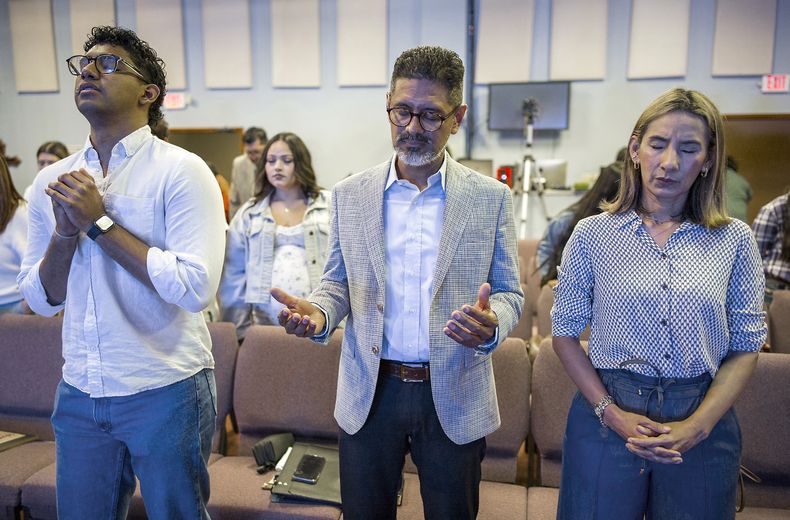 José Luis Orozco, un pastor nicaragüense, reza con su hijo Josías (izquierda) y su esposa Ruth, antes de dirigirse a los miembros de la congregación, en Taylor, Texas, el 15 de junio de 2025. (AP Foto/Rodolfo González)