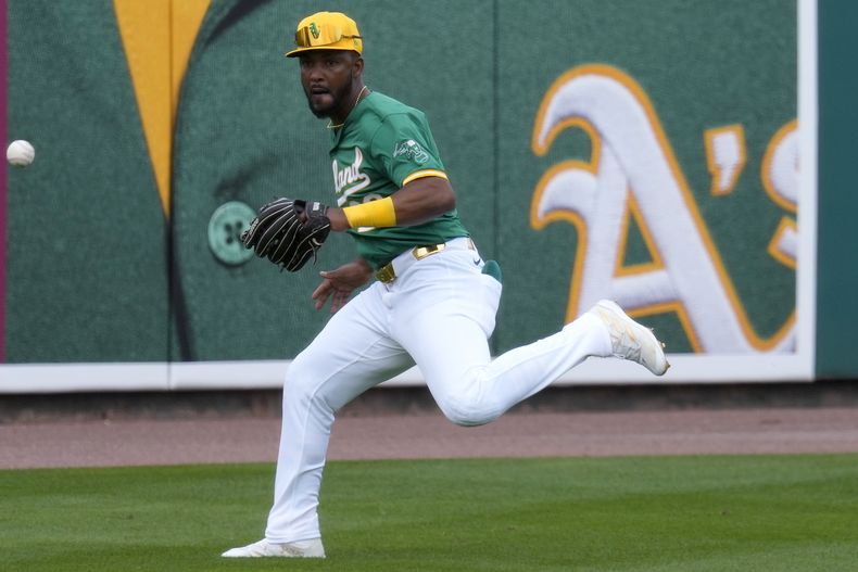 Miguel Andújar, de los Atléticos de Oakland, persigue un sencillo de Dylan Moore, de los Marineros de Seattle, en el juego de pretemporada realizado el martes 12 de marzo de 2024 en Mesa, Arizona (AP Foto/Matt York)