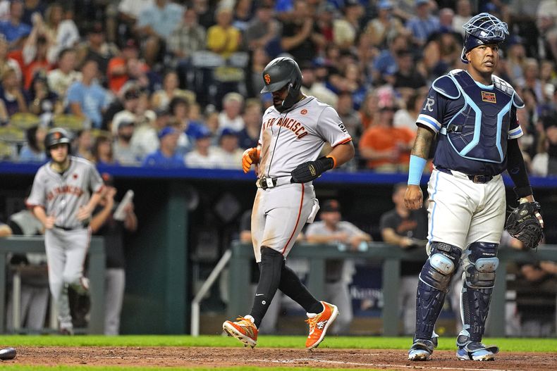 El boricua Heliot Ramos, de los Gigantes de San Francisco, anota frente al venezolano Salvador Pérez, de los Reales de Kansas City, en el juego del viernes 20 de septiembre de 2024 (AP Foto/Charlie Riedel)