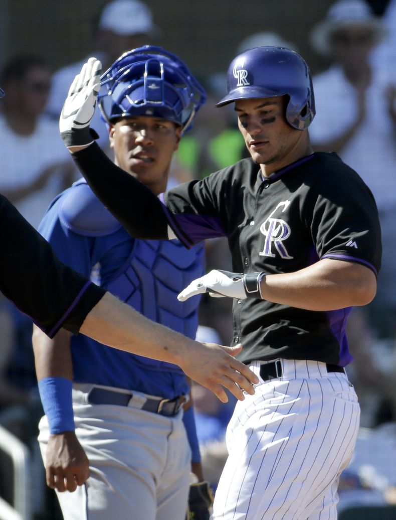 El catcher de los Reales, Salvador P&eacute;rez, izquierda, observa una jugada en un partido contra Colorado el lunes, 24 de marzo de 2014, en Scottsdale, Arizona. (AP Photo/Chris Carlson)