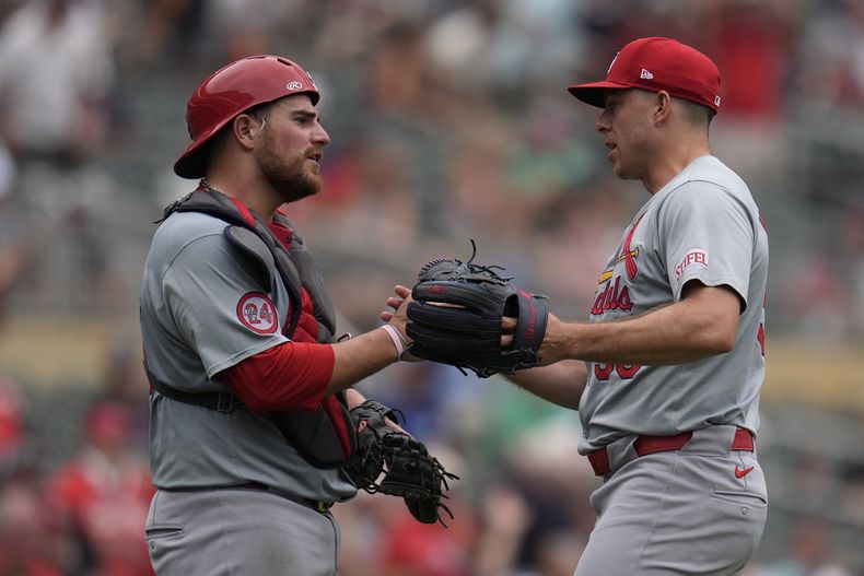 El receptor venezolano de los Cardenales de San Luis, Pedro Pagés (izquierda) y el relevista Ryan Helsey en apretón de manos luego del triunfo ante los Mellizos de Minnesota, el domingo 25 de agosto de 2024, en Mineápolis. (AP Foto/Abbie Parr)