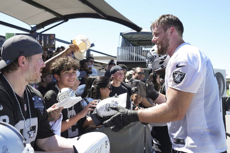 El tackle de los Raiders de Las Vegas Kolton Miller firma autógrafos al final de la práctica del campamento de entrenamiento el domingo 27 de julio del 2025. (AP Foto/Candice Ward)