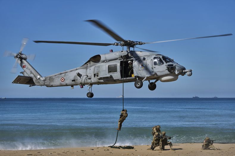 Soldados turcos se bajan de un helicóptero como parte de maniobras militares de la OTAN en Barbate, España, el 28 de marzo del 2025. (AP foto/Bernat Armangue)