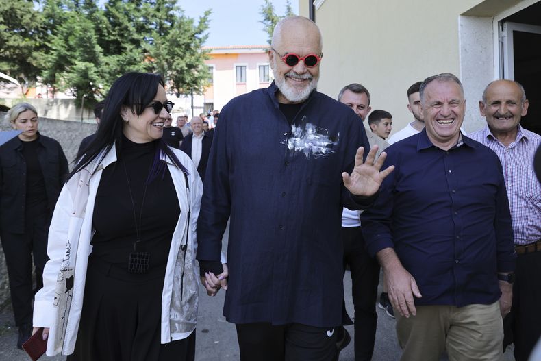 Edi Rama, primer ministro y líder del Partido Socialista de Albania, y su esposa Linda (a la izquierda) salen de un centro de votación en Tirana, Albania, el 11 de mayo del 2025. (AP foto/Vlasov Sulaj)